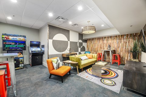 a living room with couches and chairs and a video game